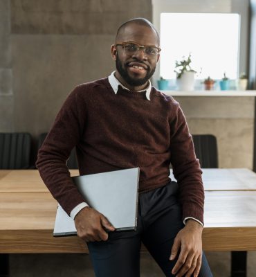 homme-souriant-portant-ordinateur-portable